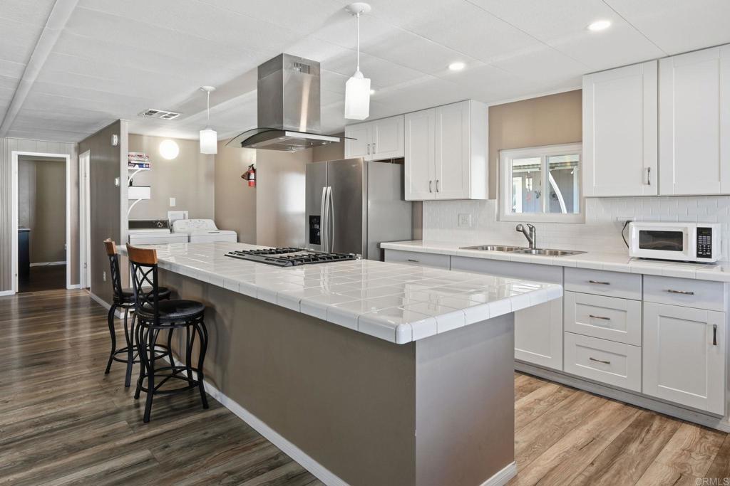 a kitchen with stainless steel appliances kitchen island granite countertop a sink and cabinets