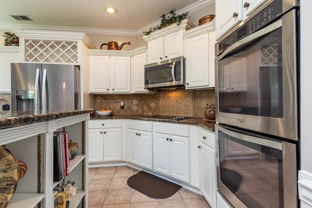 1725 John Ridge Drive Collierville, TN 38017 - Photo 13 of 34 a kitchen with stainless steel appliances granite countertop a stove a microwave and a sink