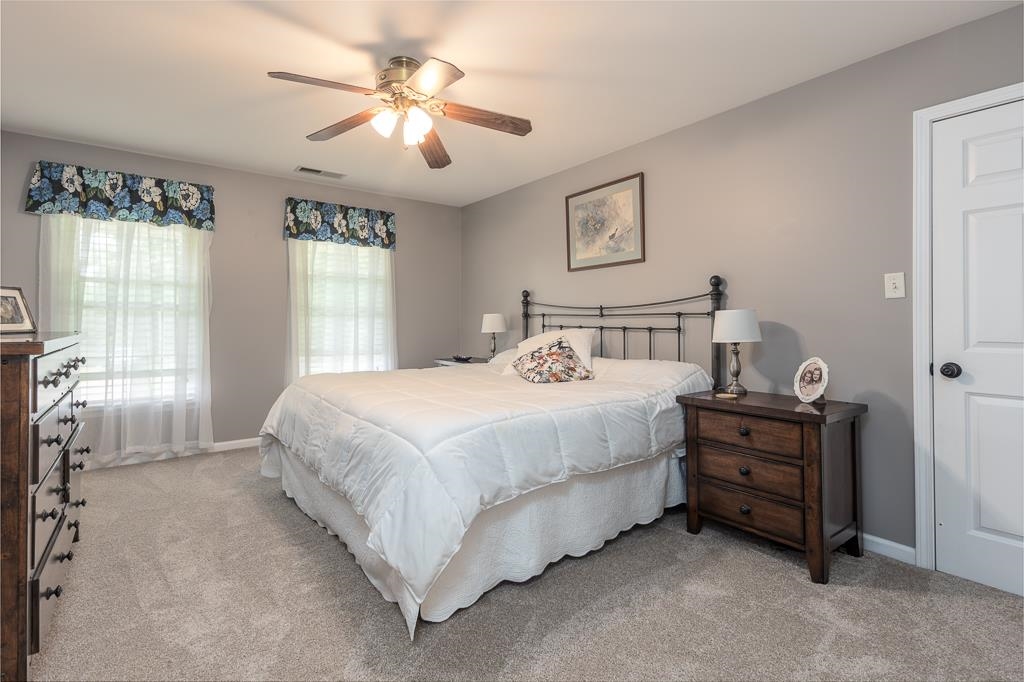 1725 John Ridge Drive Collierville, TN 38017 - Photo 22 of 34 a bedroom with a bed and a chandelier