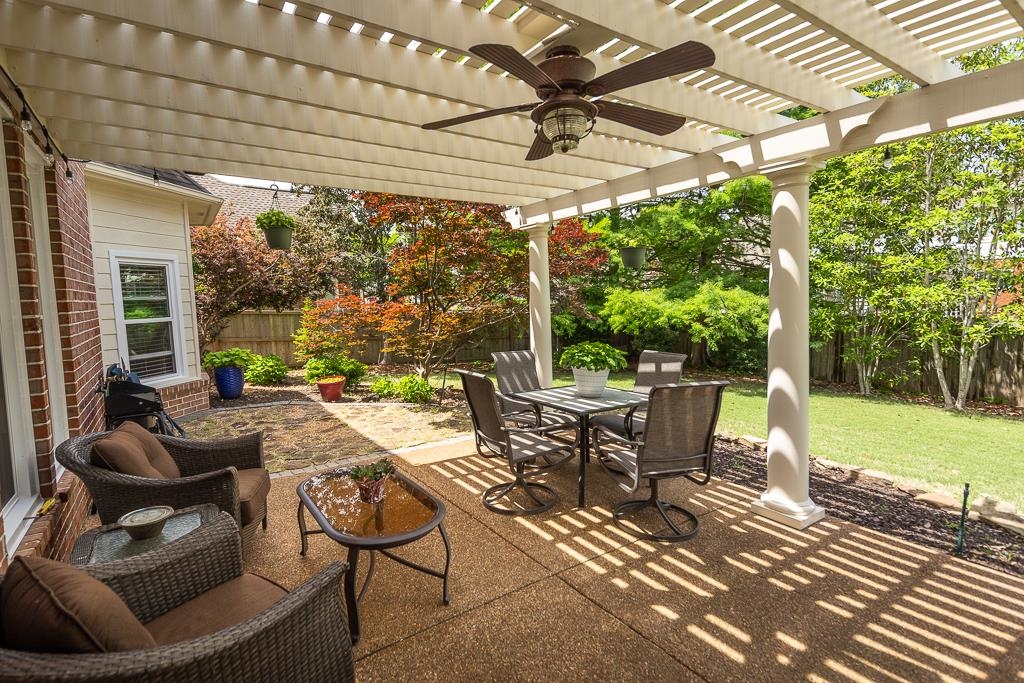 1725 John Ridge Drive Collierville, TN 38017 - Photo 29 of 34 a view of a patio with a dining table and chairs under an umbrella