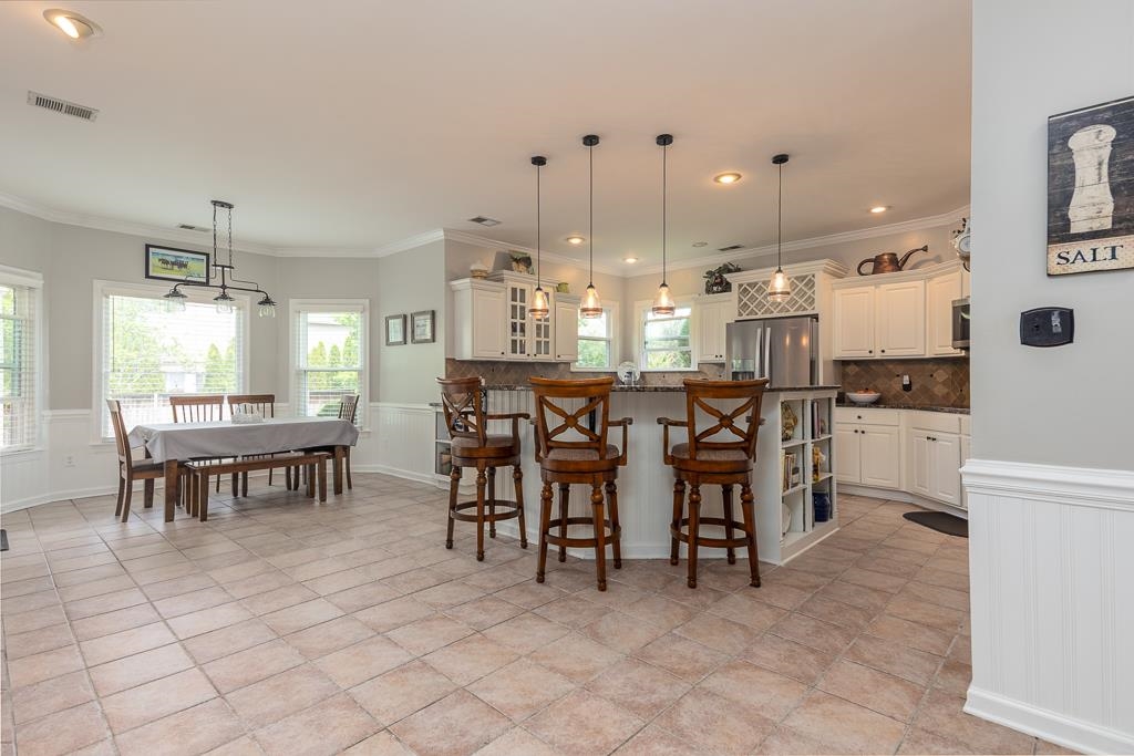1725 John Ridge Drive Collierville, TN 38017 - Photo 9 of 34 a kitchen with kitchen island a dining table and chairs
