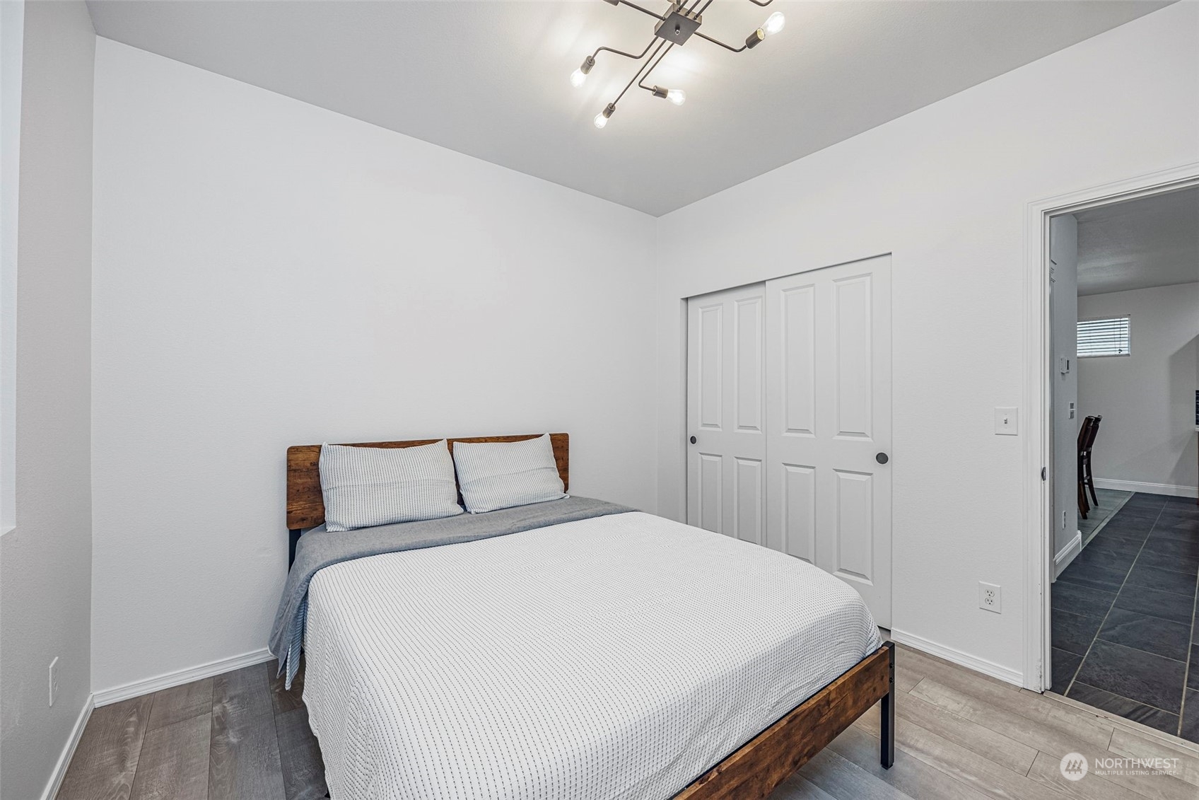 8975 Campus Meadows Loop Northeast Lacey, WA 98516 - Photo 17 of 36 a bedroom with a white bed and wooden floor