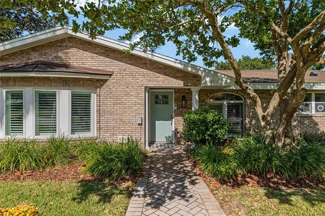 a front view of a house with a yard and potted plants