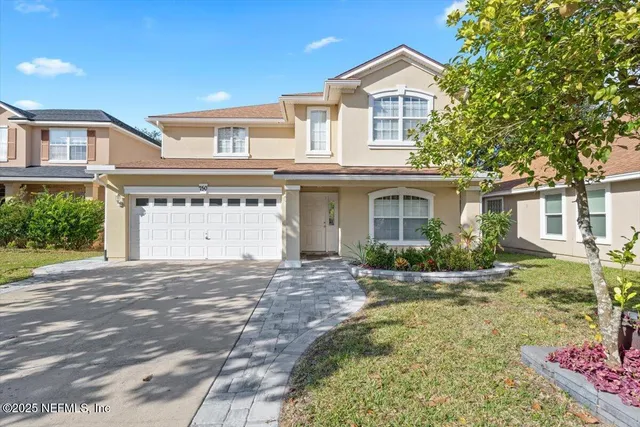 a front view of a house with a yard and garage
