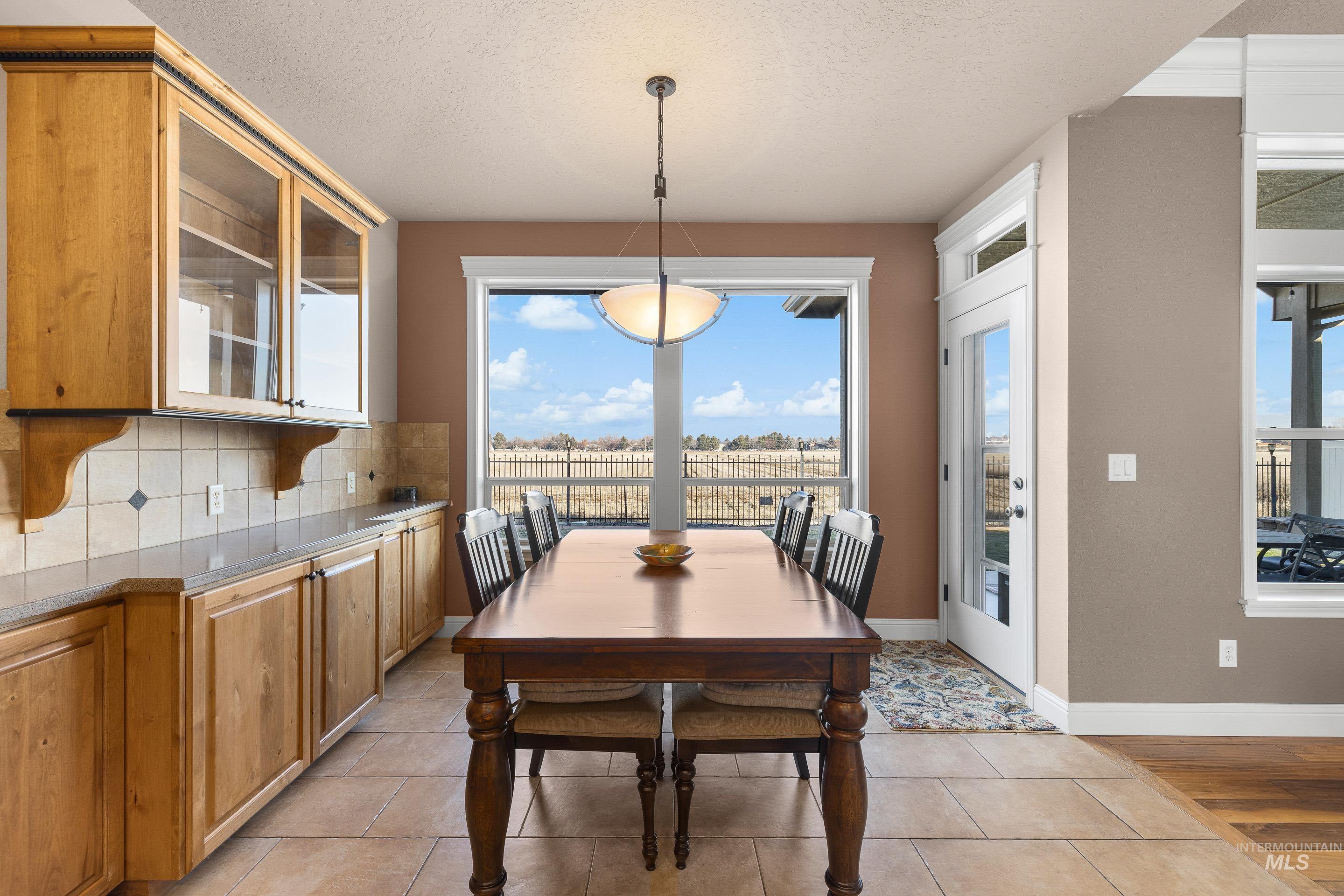2208 East Sicily Street Meridian, ID 83642 - Photo 15 of 50 Dining area featuring a textured ceiling, healthy amount of natural light, and light tile patterned flooring