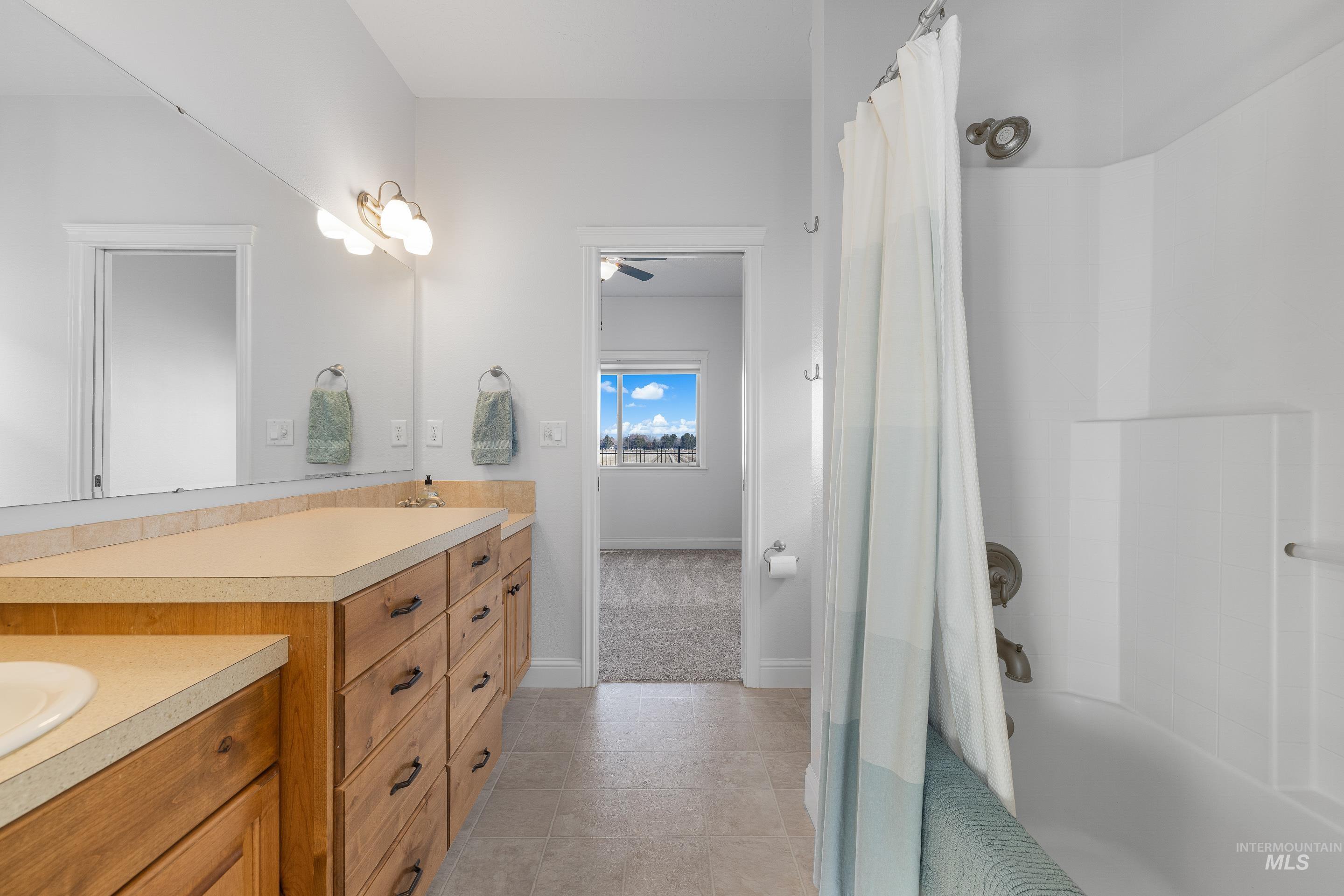 2208 East Sicily Street Meridian, ID 83642 - Photo 30 of 50 Bathroom with double vanity, shower / bath combination with curtain, a ceiling fan, and light tile patterned floors