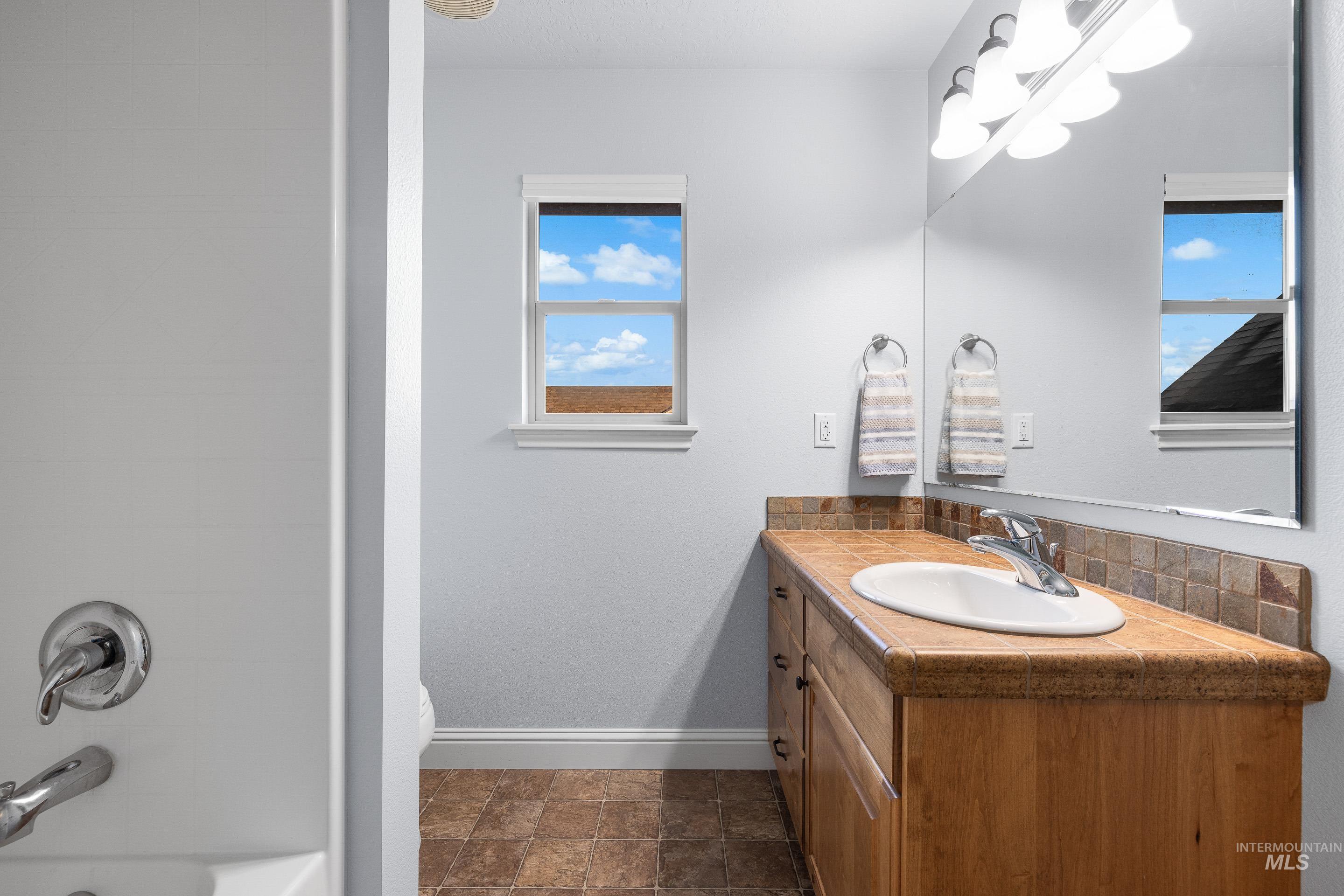 2208 East Sicily Street Meridian, ID 83642 - Photo 34 of 50 Full bath with vanity, stone finish floors, and tub / shower combination