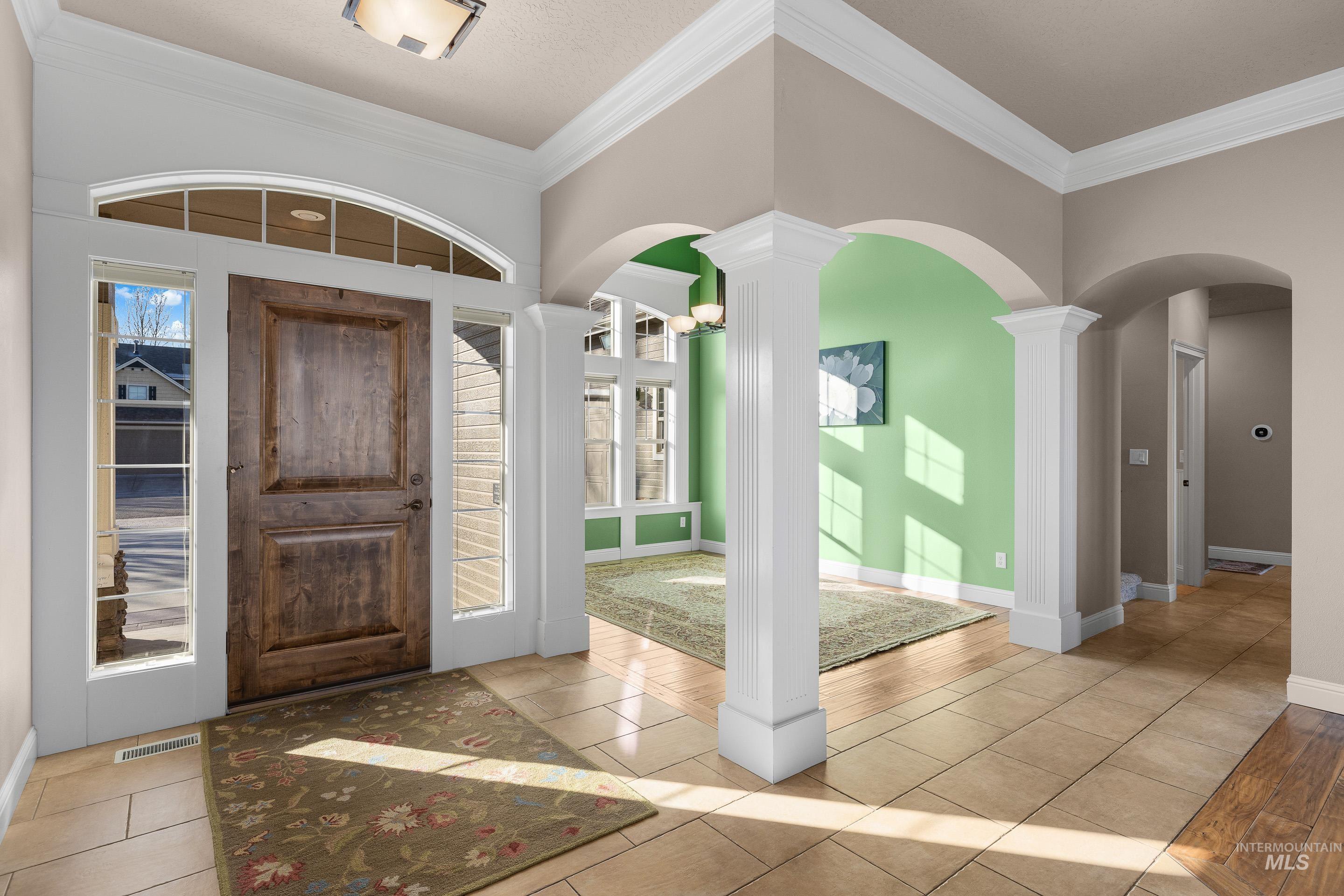 2208 East Sicily Street Meridian, ID 83642 - Photo 6 of 50 Foyer entrance featuring arched walkways, crown molding, and light tile patterned flooring