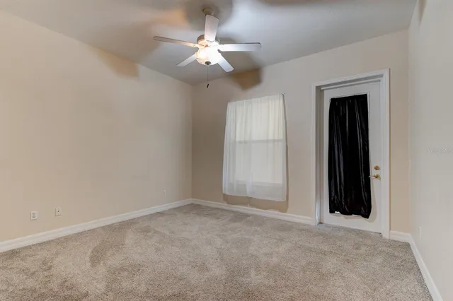 an empty room with a chandelier fan