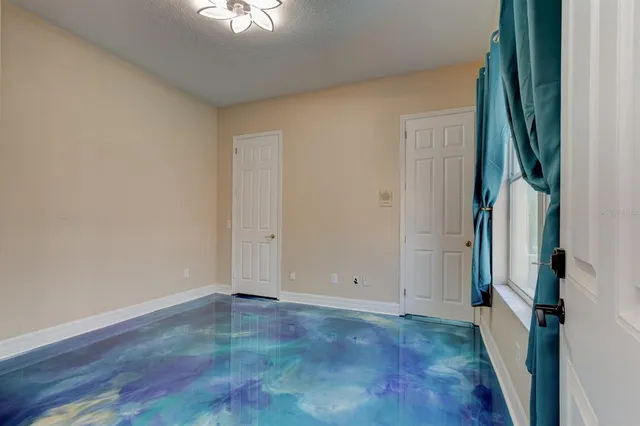 a view of a room with wooden floor and a window