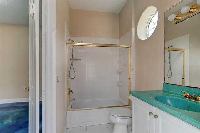 a bathroom with a granite countertop sink mirror toilet and shower