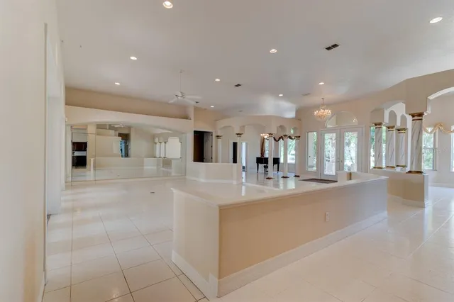 a large white kitchen with a large counter top and living room