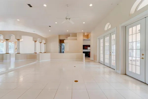 a large white kitchen with a large counter top and living room
