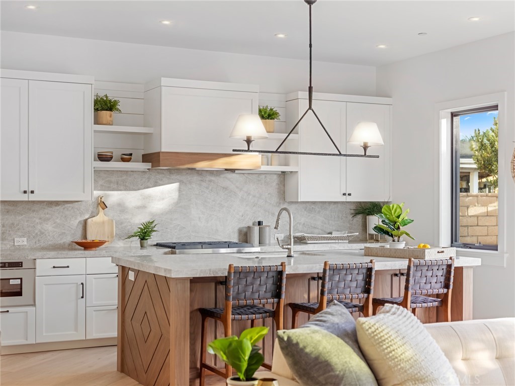 379 La Perle Place Costa Mesa, CA 92627 - Photo 2 of 8 a kitchen with stainless steel appliances granite countertop a stove a sink and a refrigerator