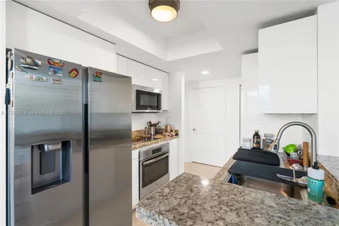 a kitchen with stainless steel appliances granite countertop a sink a stove and refrigerator