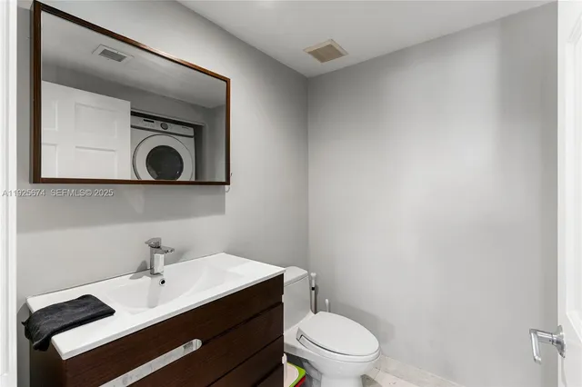 a bathroom with a toilet a sink and mirror