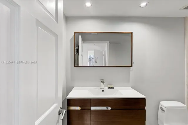 a bathroom with a sink vanity and mirror