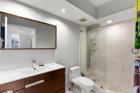 a bathroom with a toilet a sink and glass door