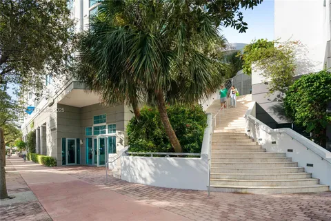 a view of a white house with a yard and potted plants