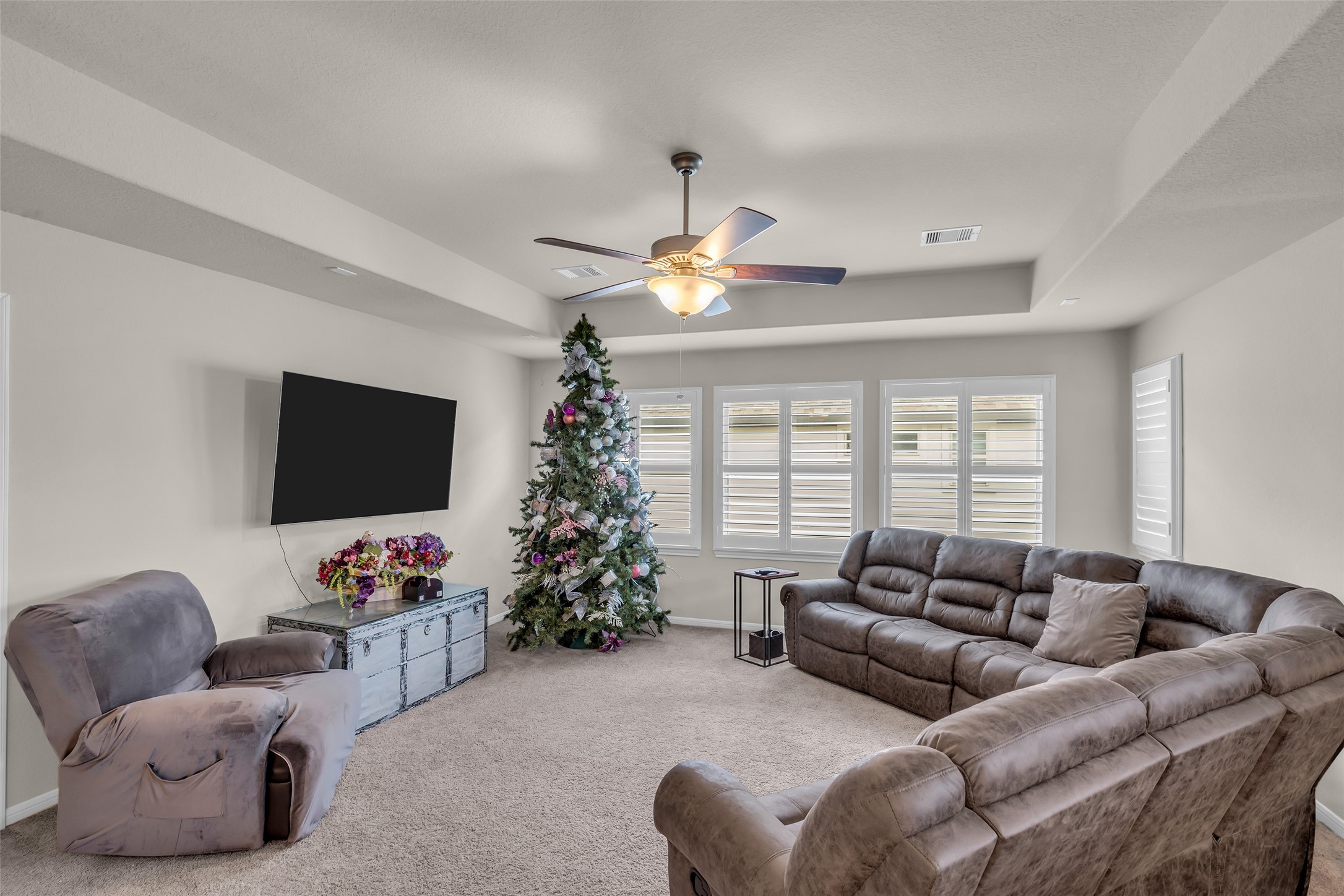 7211 Julie Pond Lane Spring, TX 77389 - Photo 28 of 45 Spacious media room with plush seating, abundant natural light, and a ceiling fan, perfect for relaxation and entertainment.