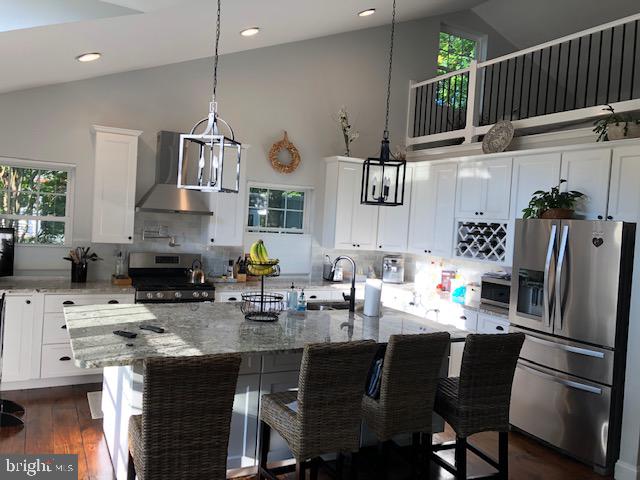 360 Bay Reach Rehoboth Beach, DE 19971 - Photo 24 of 28 a kitchen with stainless steel appliances a sink a stove a refrigerator cabinets and dining table