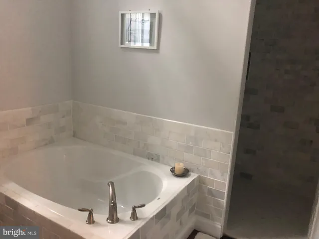a bath tub sitting in a bathroom next to a sink