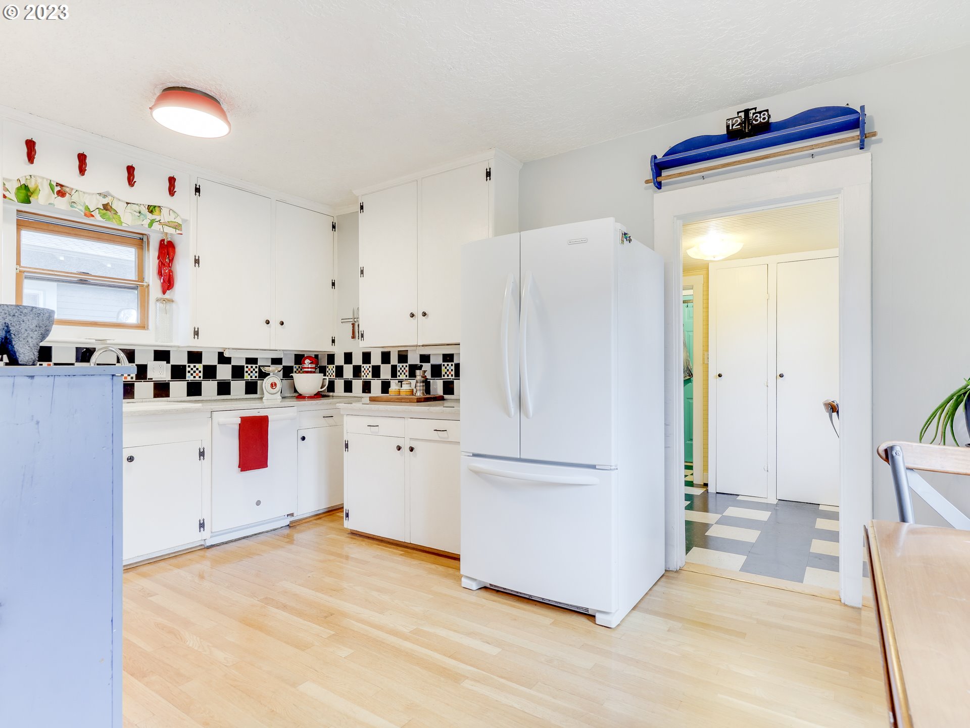 4936 Southeast 76th Avenue Portland, OR 97206 - Photo 13 of 47 a kitchen with a refrigerator and white cabinets