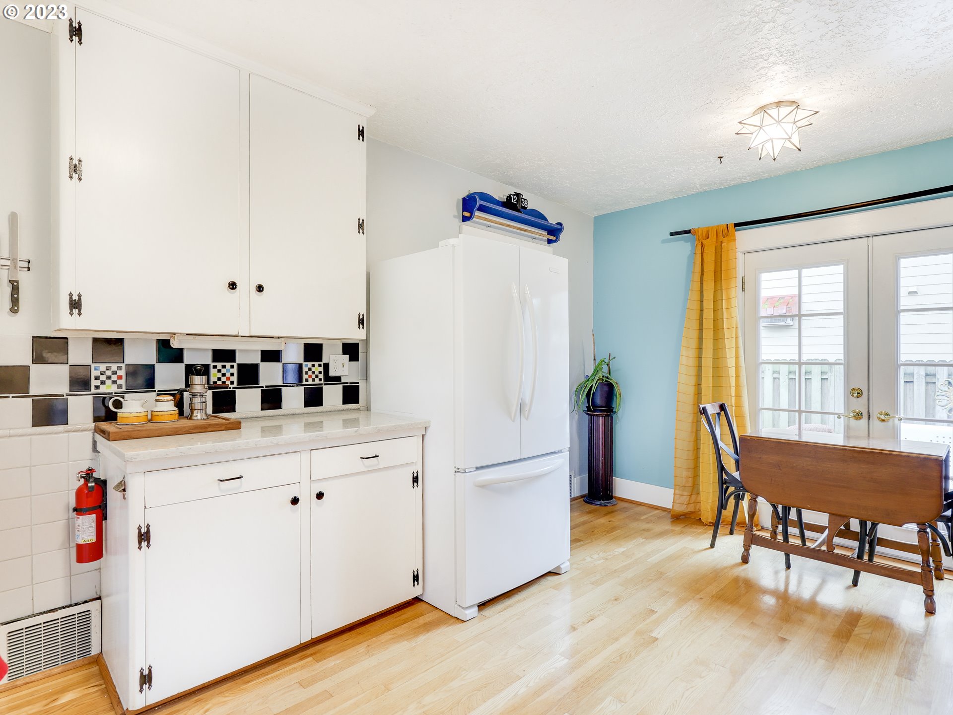 4936 Southeast 76th Avenue Portland, OR 97206 - Photo 16 of 47 a kitchen with stainless steel appliances a stove a refrigerator a dining table and chairs