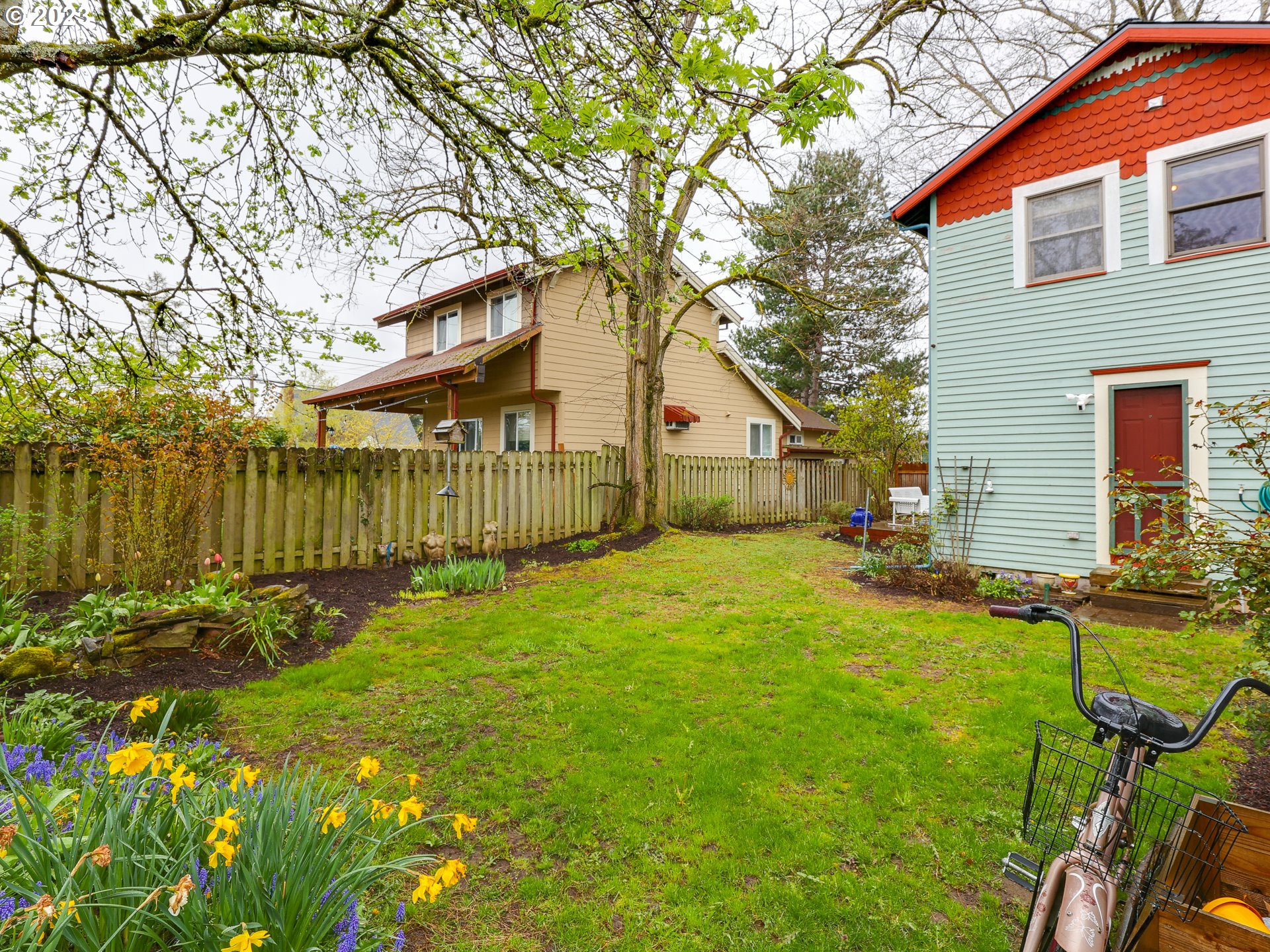 4936 Southeast 76th Avenue Portland, OR 97206 - Photo 36 of 47 a view of backyard of house with wooden fence and a large tree