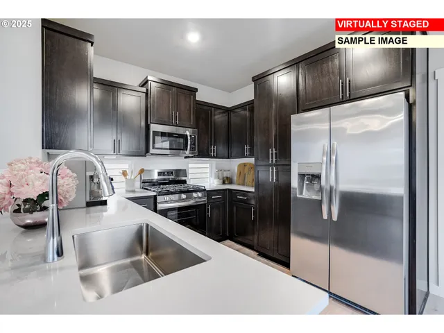 a kitchen with granite countertop a refrigerator and a sink