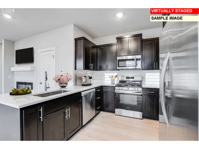 a kitchen with kitchen island stainless steel appliances a sink stove top oven and refrigerator