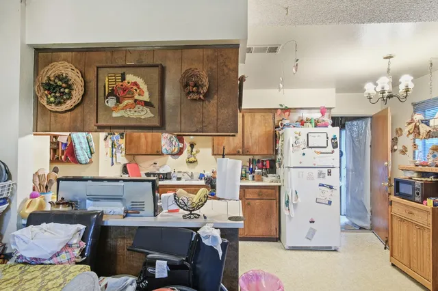 a view of a kitchen with fridge and workspace