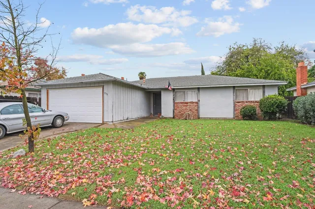 a backyard of a house with table and chairs