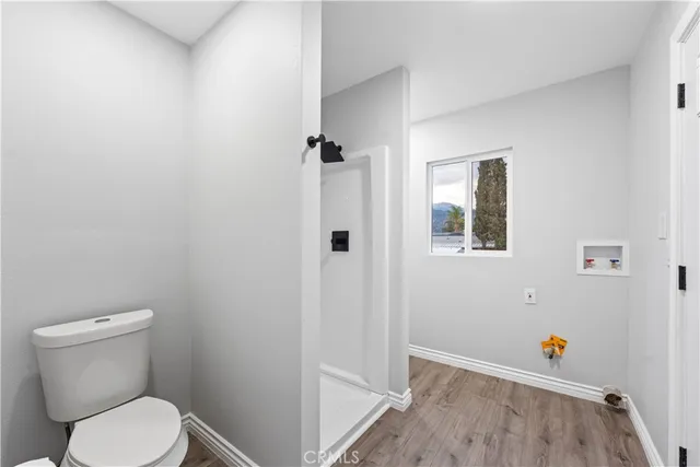 a white toilet sitting next to a shower