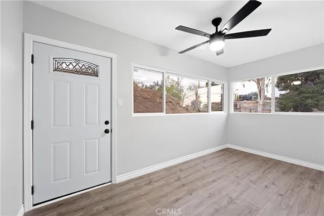 a view of a big room with wooden floor and windows