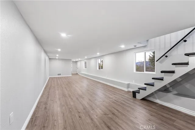 a view of an empty room with stairs wooden floor and stairs