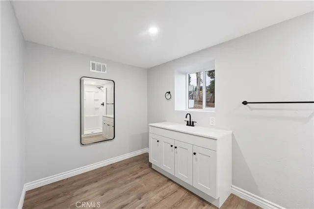 a bathroom with a sink a mirror and a window