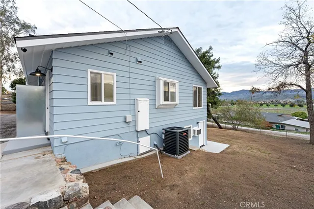 a white house that has a tree on the side of it