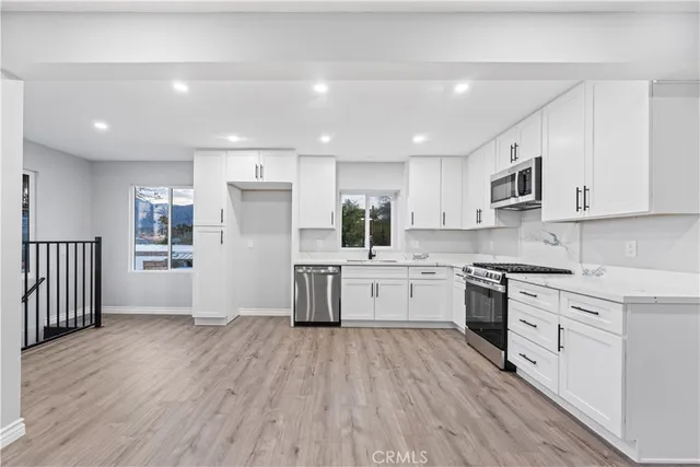 a kitchen with stainless steel appliances sink refrigerator and cabinets