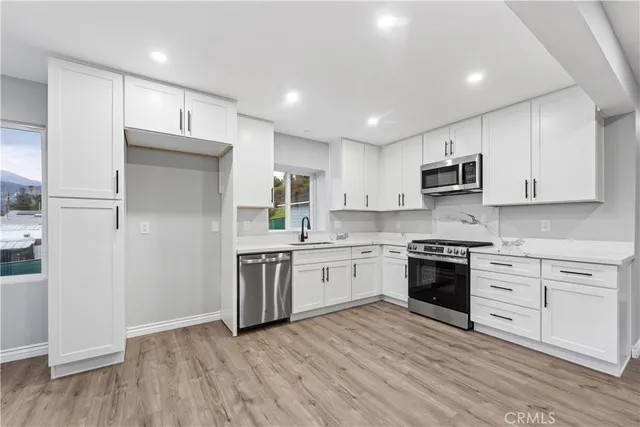 a kitchen with a refrigerator stove top oven and sink