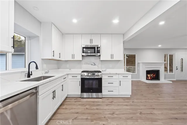 a kitchen with stainless steel appliances granite countertop a stove sink and cabinets