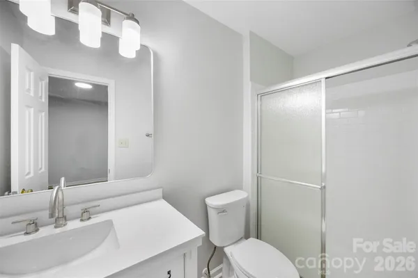 a bathroom with a granite countertop toilet and a shower