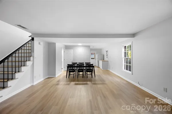 a view of a livingroom with wooden floor and stairs