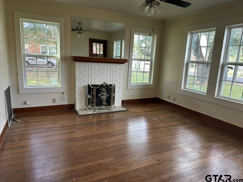 1717 East Houston Street Tyler, TX 75702 - Photo 6 of 10 an empty room with wooden floor fireplace and windows