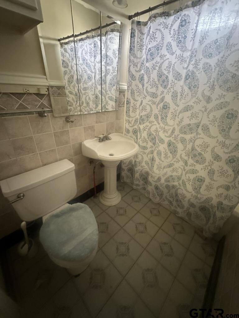 1717 East Houston Street Tyler, TX 75702 - Photo 9 of 10 a bathroom with a sink toilet and shower