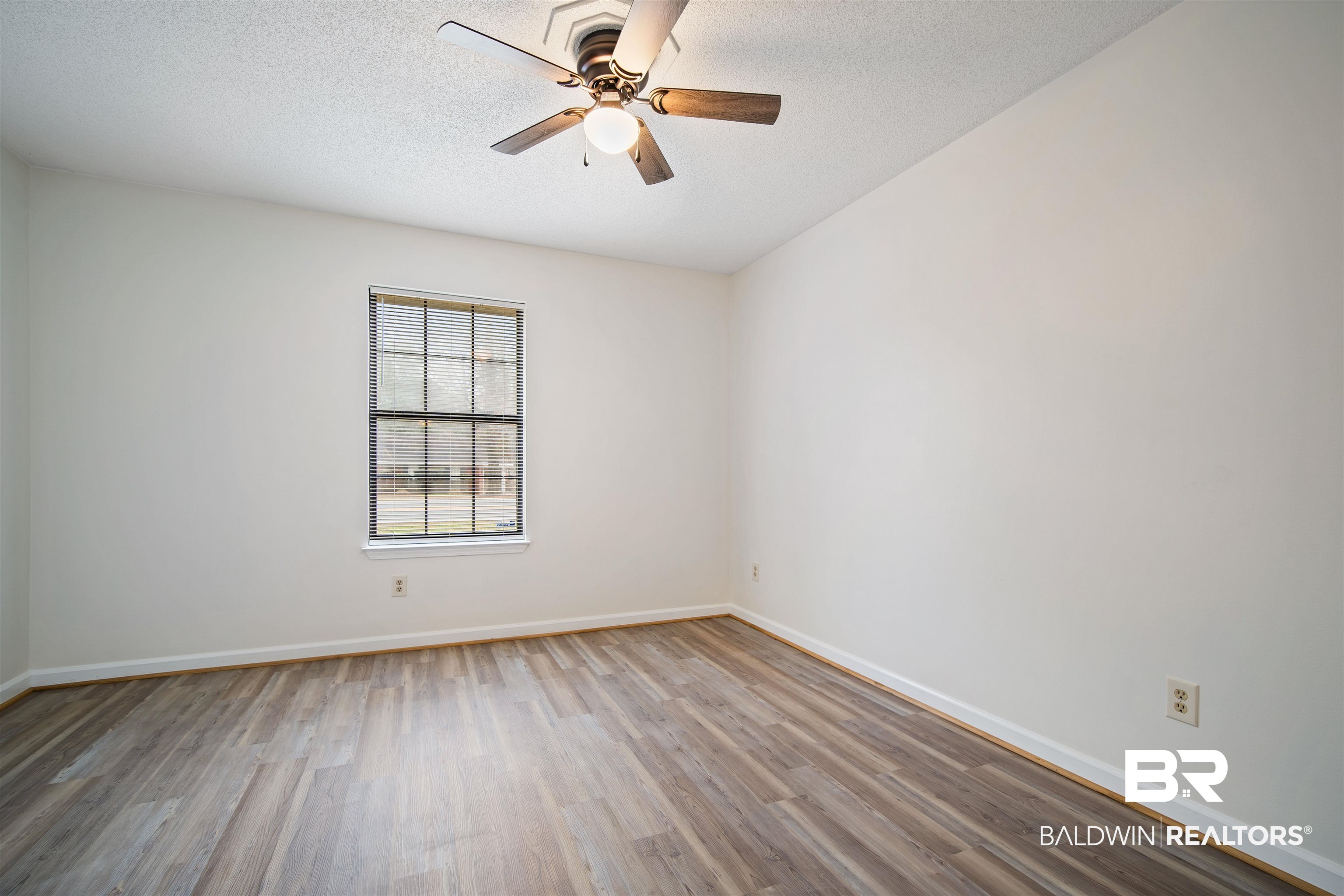 6701 Howells Ferry Road Mobile, AL 36618 - Photo 17 of 25 Unfurnished room featuring ceiling fan, light hardwood / wood-style flooring, and a textured ceiling