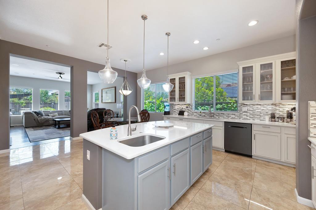 1721 Bella Circle Lincoln, CA 95648 - Photo 16 of 66 a large kitchen with kitchen island a large counter top space a sink a counter space and living room view