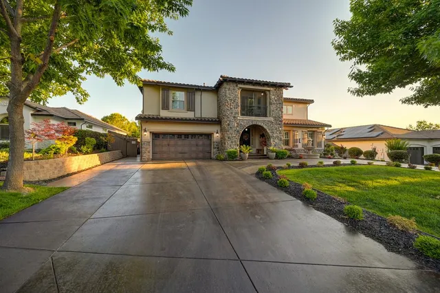 a front view of a house with a yard and potted plants