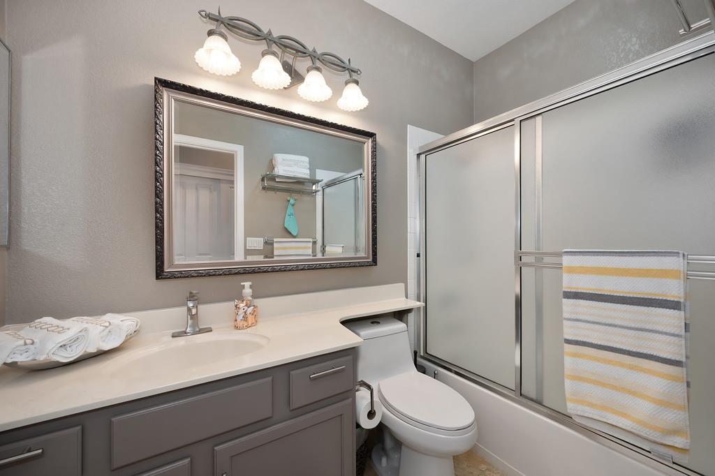 1721 Bella Circle Lincoln, CA 95648 - Photo 22 of 66 a bathroom with a granite countertop sink toilet a mirror and shower