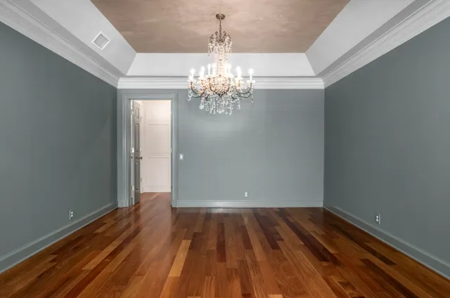 a view of a room with wooden floor and chandelier